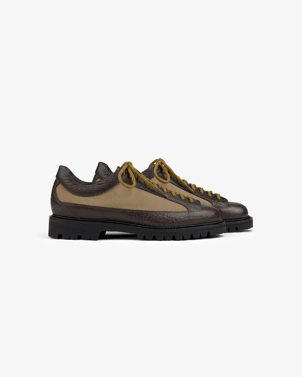 Field Boot low-top with a textured brown leather base, tan canvas upper, and a thick black lug sole.