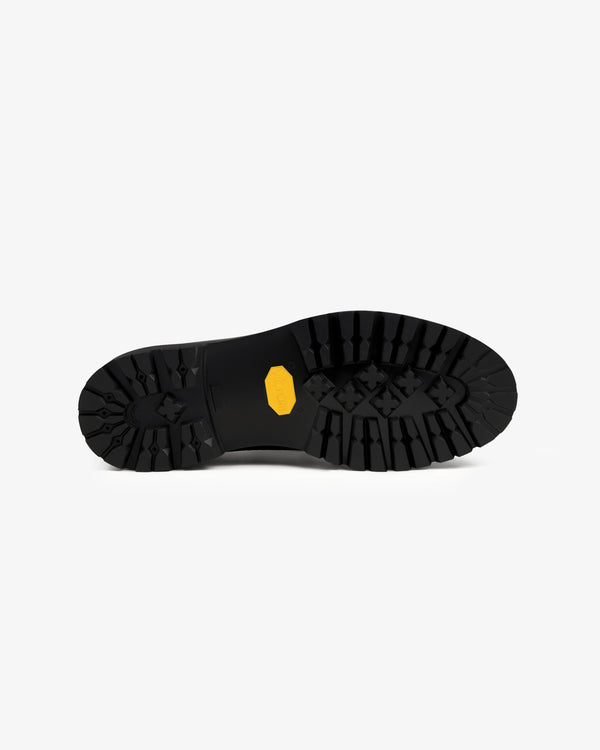 Field Boot black outsole with deep tread and a yellow rectangular logo in the center.