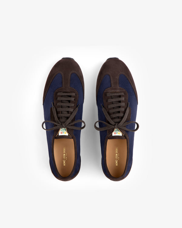 A pair of dark blue and brown Low Profile Suede Trainer low-top sneakers viewed from above.