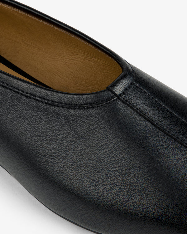 Close-up of a Leather Ballet Flat in black, featuring a center seam and tan interior lining.