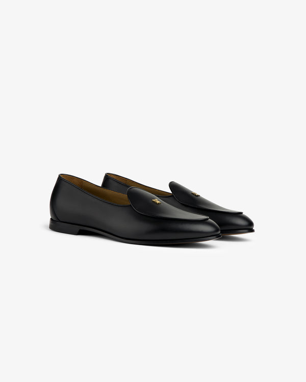 Crest Salóni Loafer: Black leather loafers with a gold bee detail, displayed on a white background.