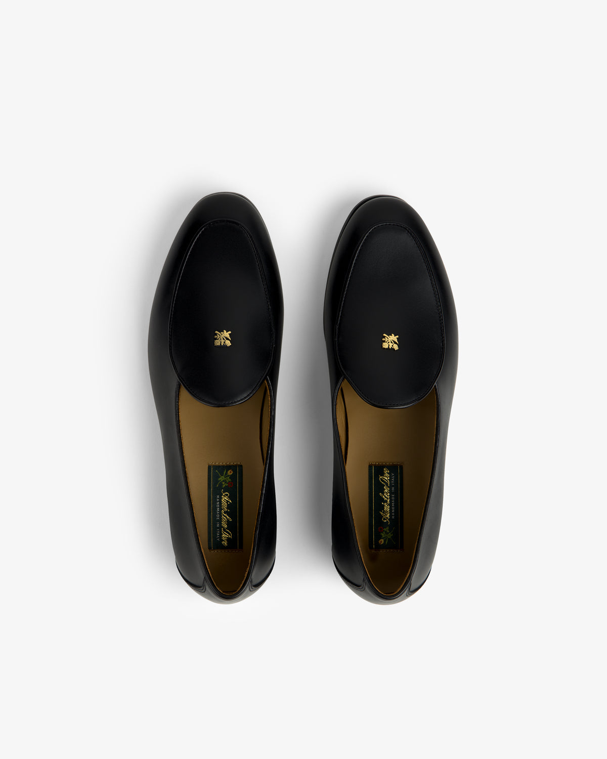 Crest Salóni Loafer: black leather pair with gold emblem, top view on a plain white background.