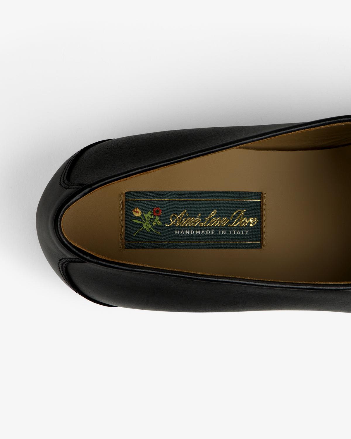Top view of Crest Salóni Loafer in black leather with Christian Dior HANDMADE IN ITALY label and flower graphic.