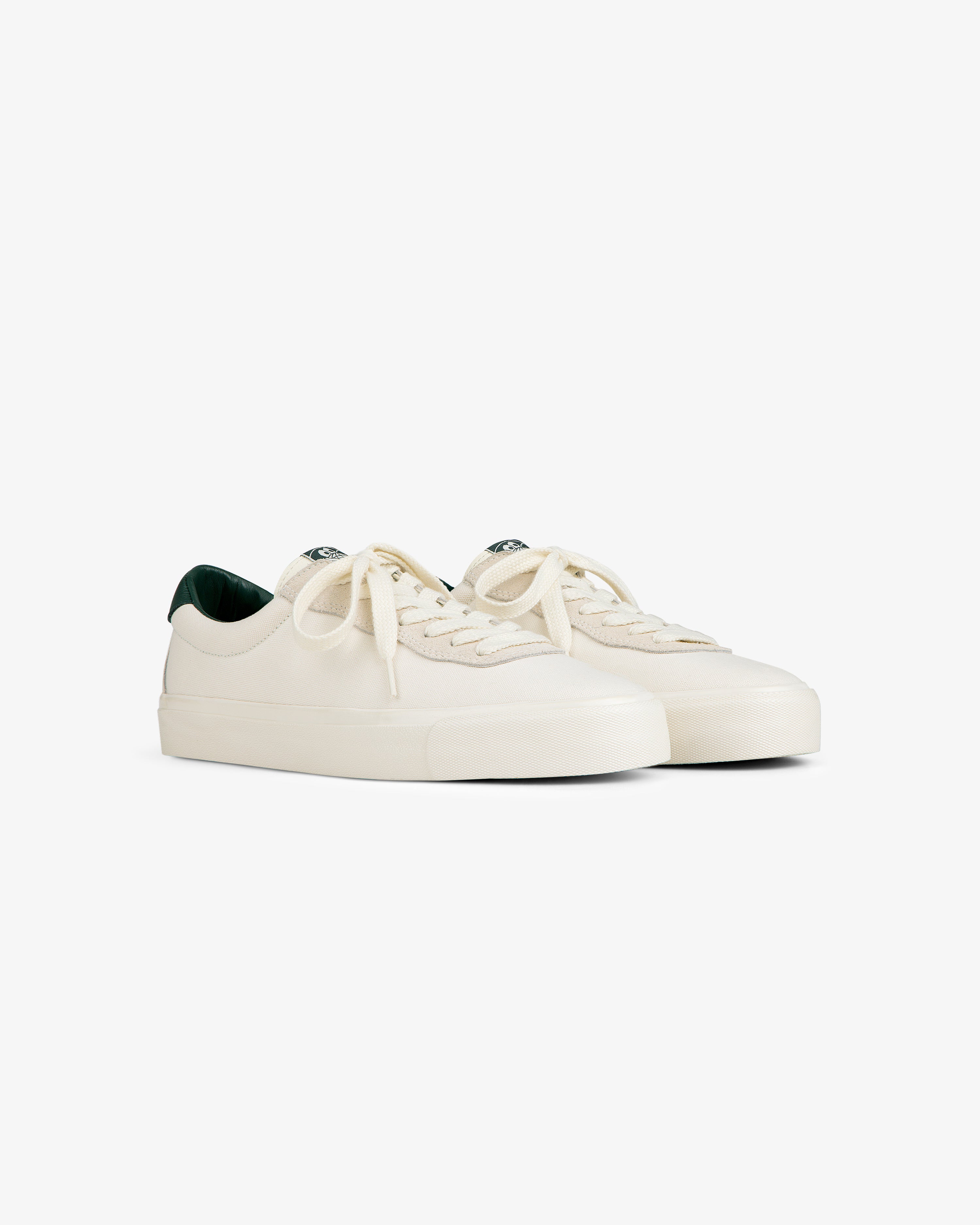 ALD / Last Resort AB VM001-LO Canvas sneakers in off-white with white laces and dark green interior on white.