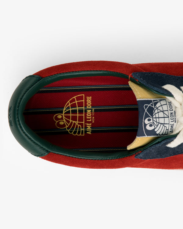 Top view of the ALD / Last Resort AB VM001-LO Suede sneaker with red, green, gold logo, and striped insole.