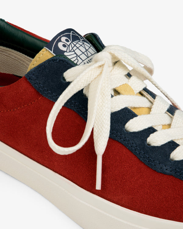 ALD / Last Resort AB VM001-LO Suede: Red suede sneaker with white laces, navy-yellow accents, and cartoon tongue detail.