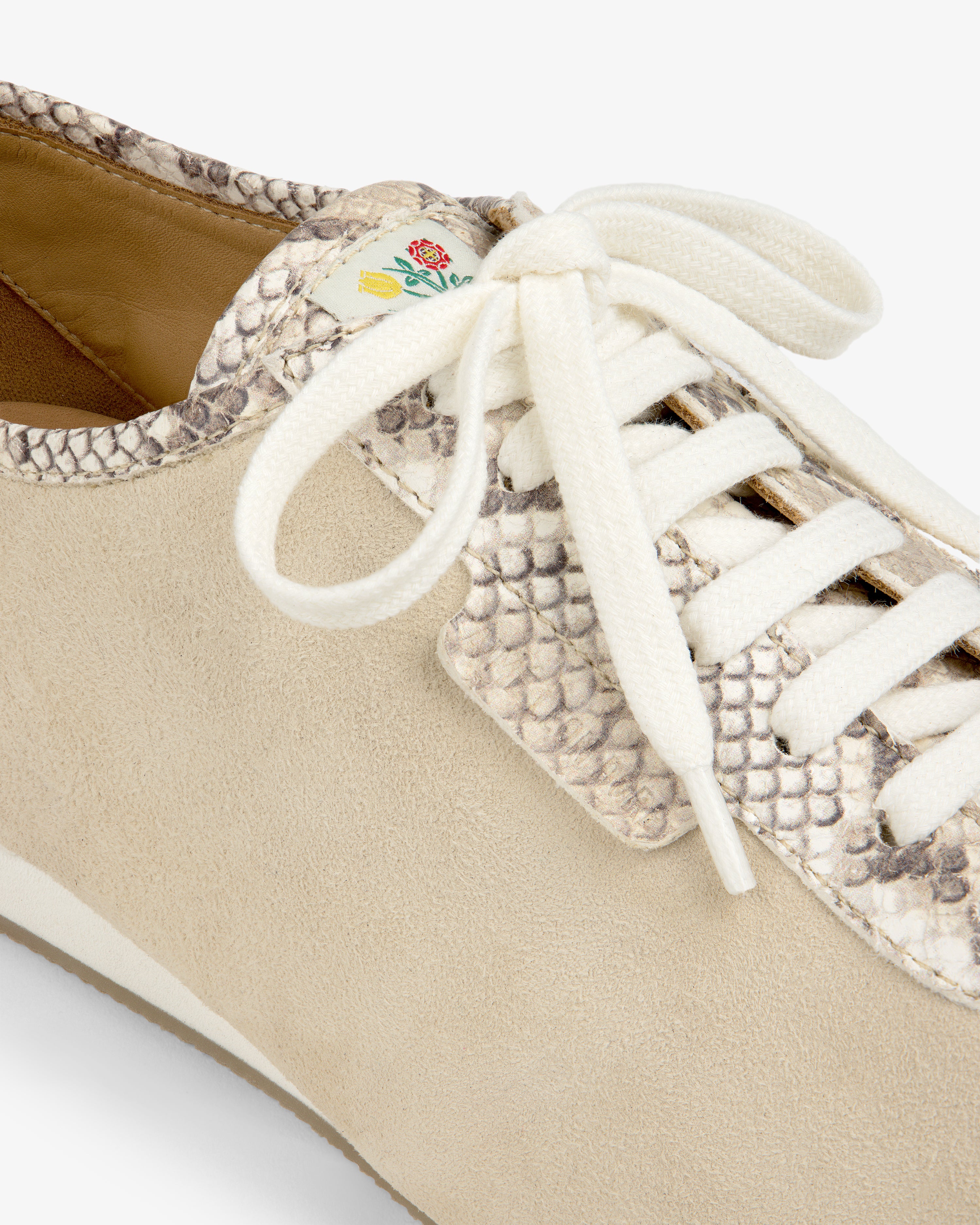 Snake Print Low Profile Suede Trainer in tan with snake-print accents, white laces, and a small floral tongue tag.