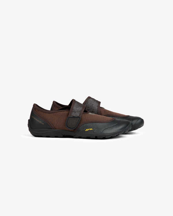 Brown low-profile ALD / New Balance MT2 slip-on shoe with a textured strap and black rubber sole.