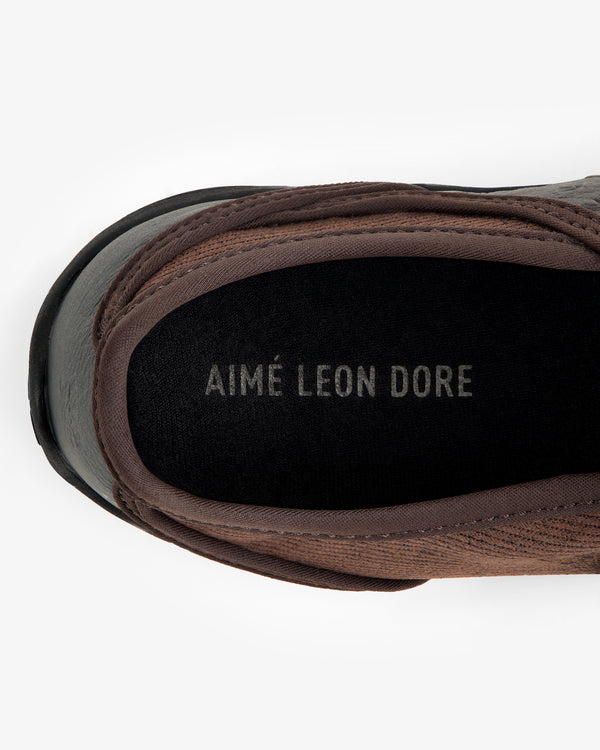 Top-down view of an ALD / New Balance MT2 slip-on shoe interior with the brand name printed on the black footbed.
