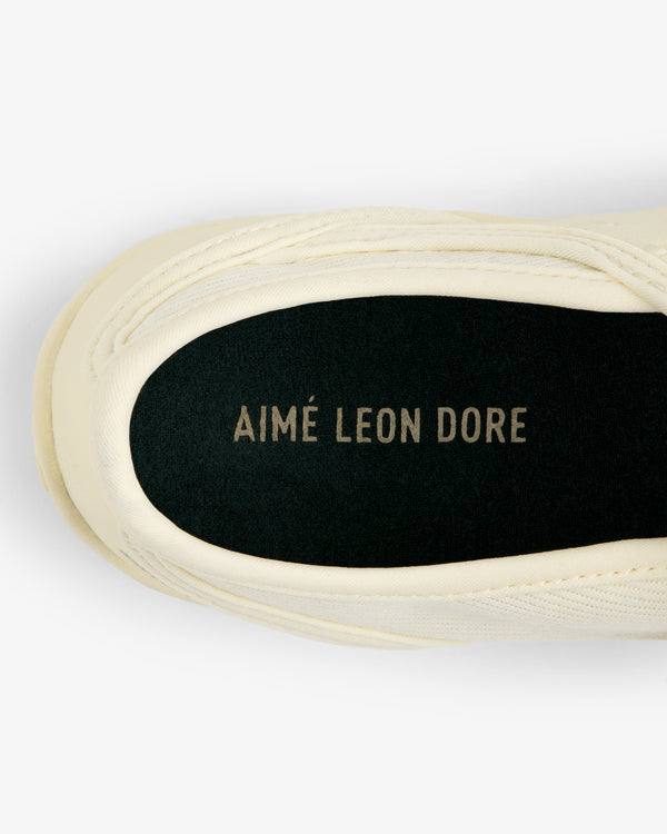 Top-down view of a cream-colored ALD / New Balance MT2 shoe interior with a black insole reading Aimé Leon Dore.