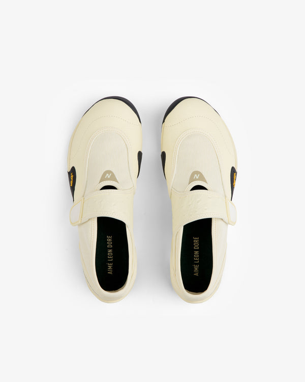 Off-white ALD / New Balance MT2 slip-on sneakers with black sole accents and a strap across the top.