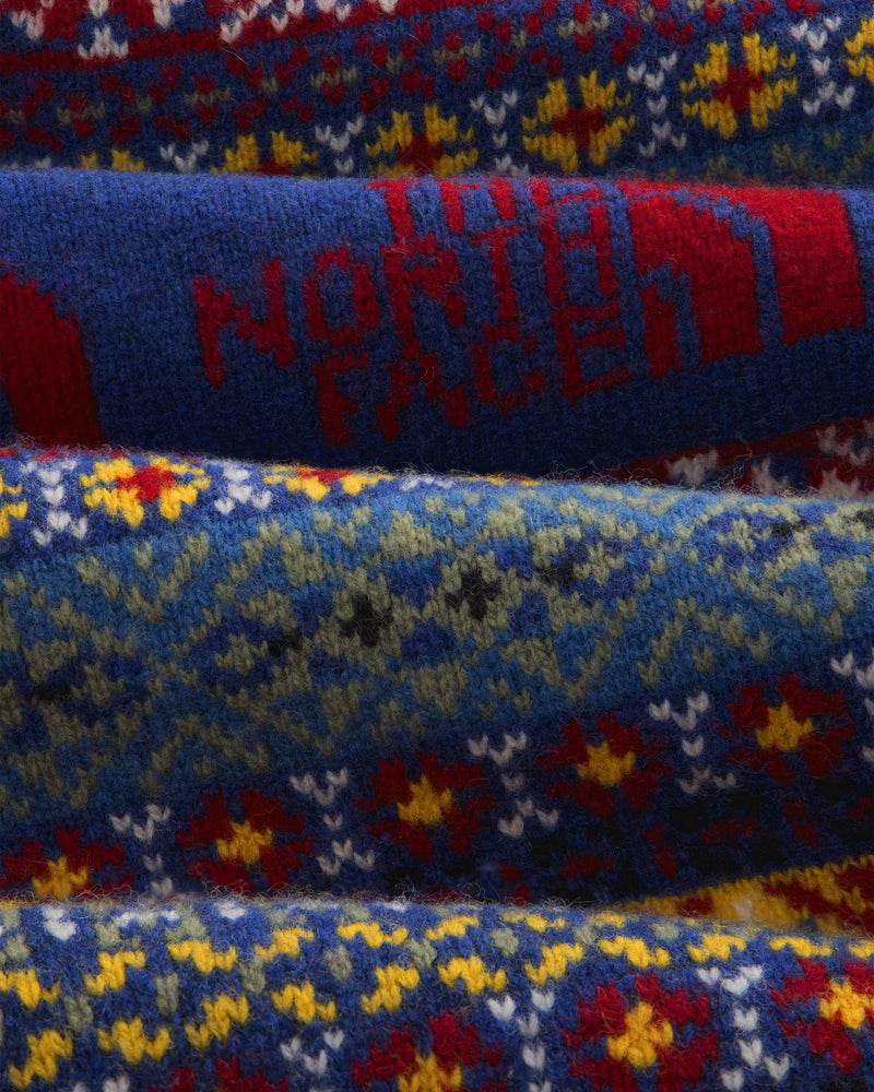 Fair Isle knit polo with colorful pattern, red North Face text, and blue background—ALD/The North Face.