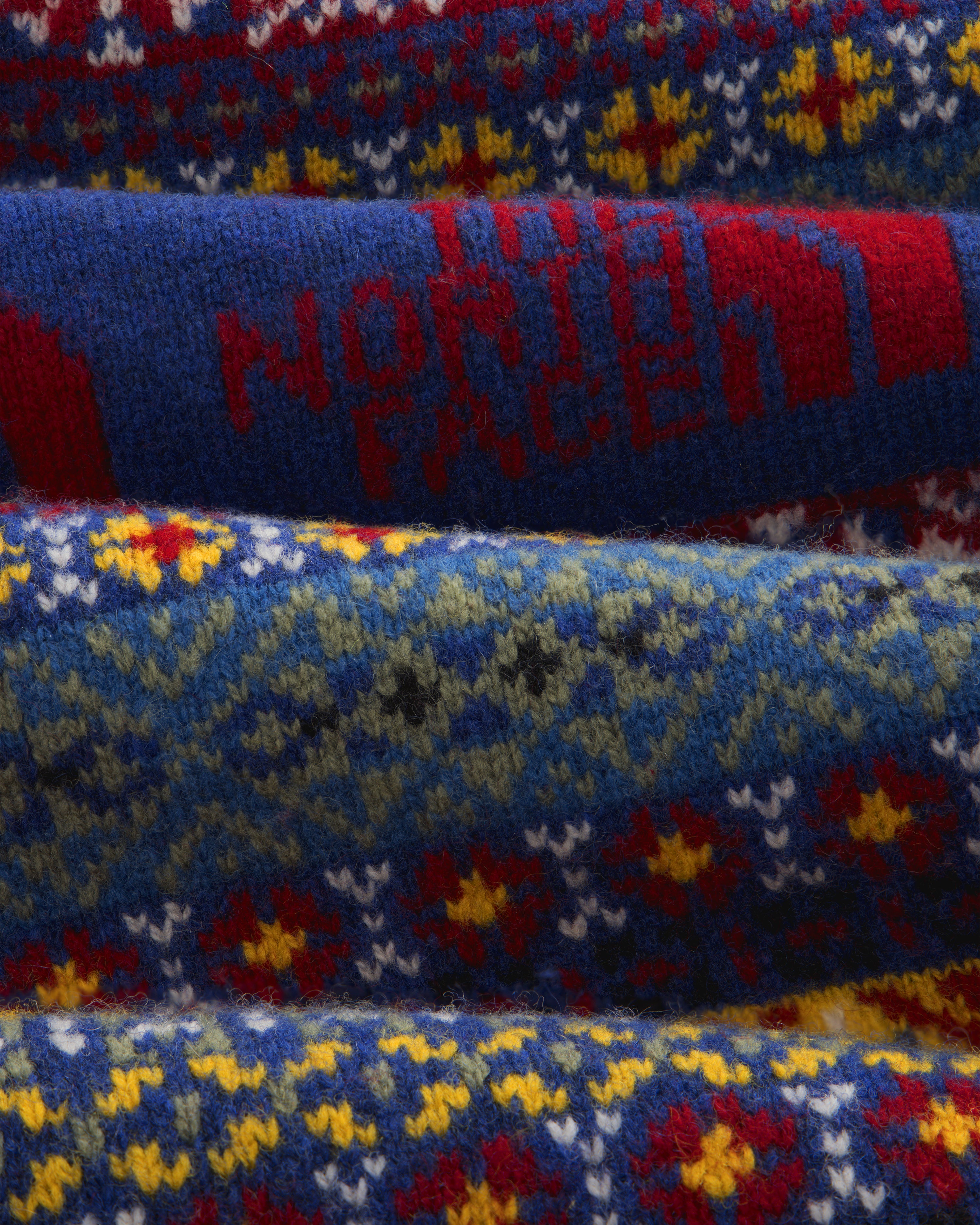 Close-up of the ALD / The North Face Fair Isle Scarf featuring colorful knit patterns and red logo on blue.