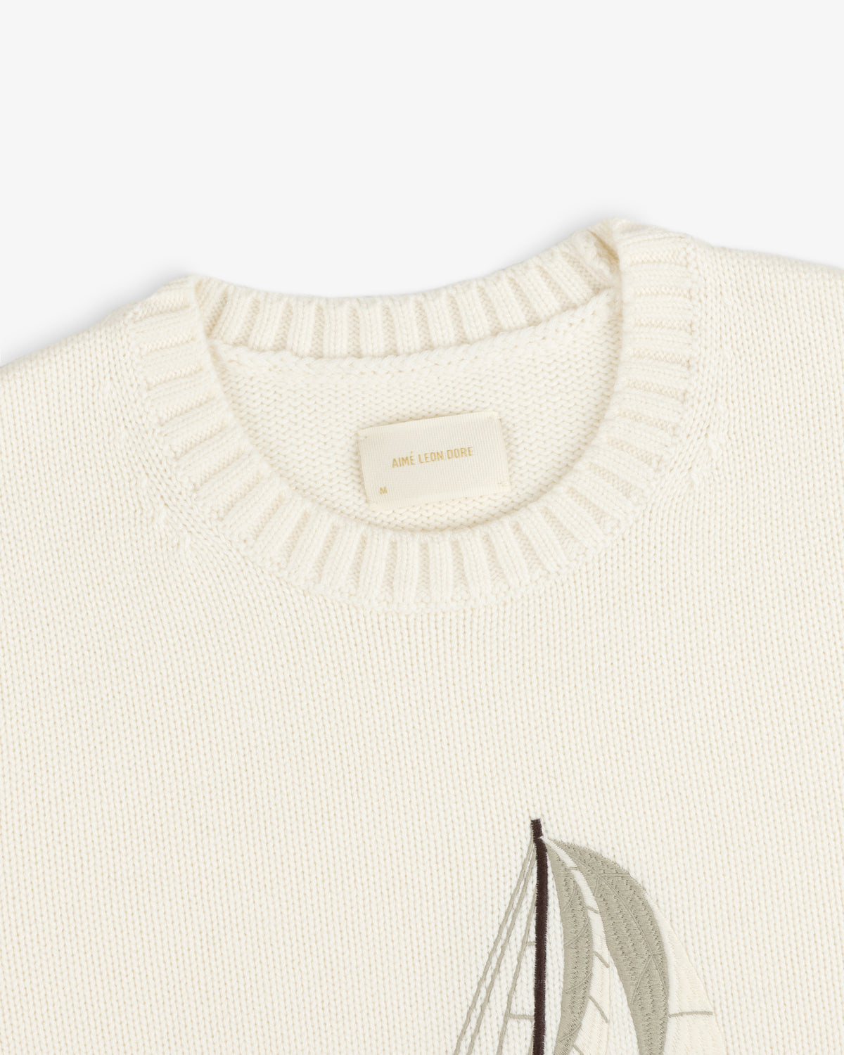 Regatta Embroidered Crewneck Sweater in cream with ribbed neckline and a partial sailboat design on the front.