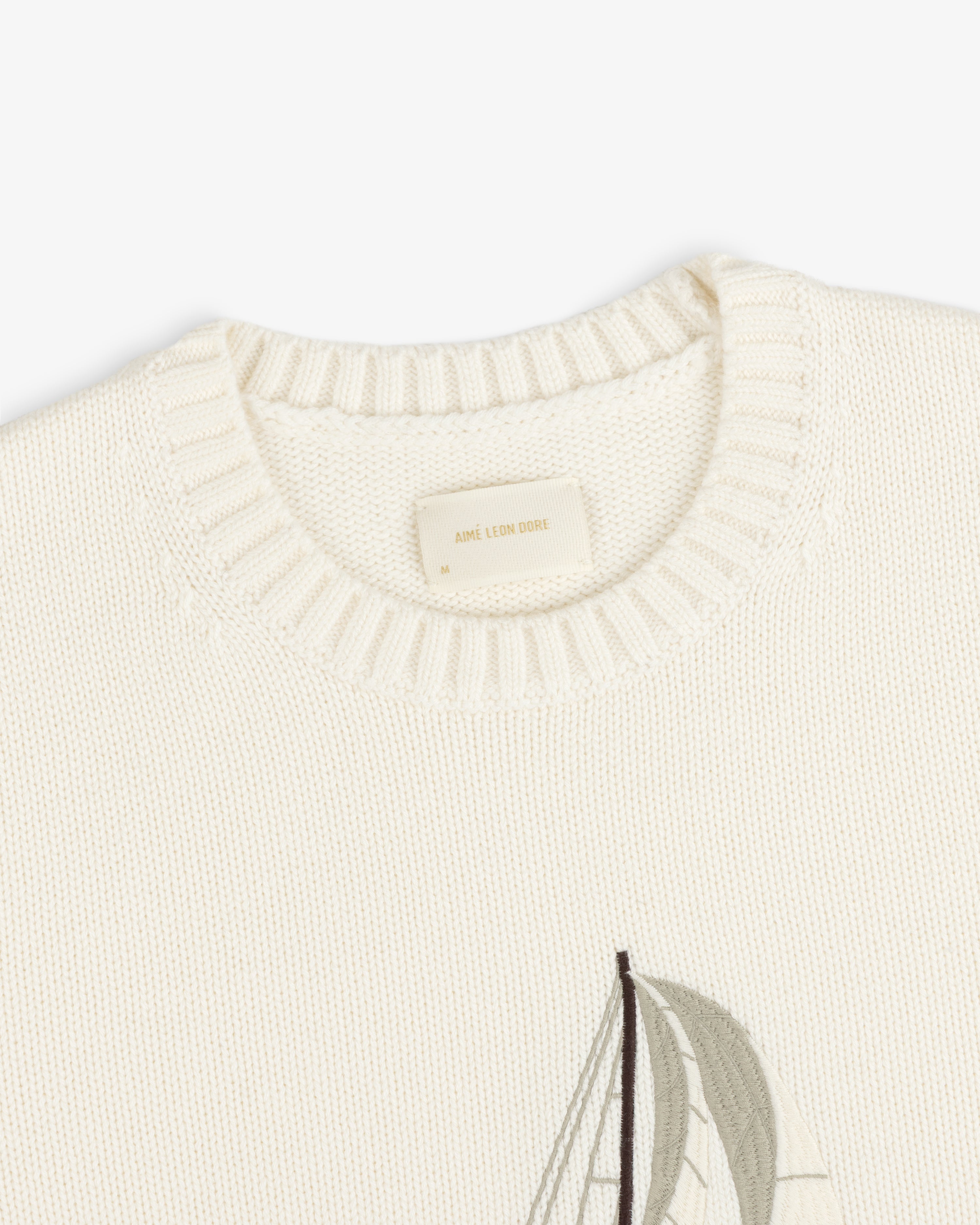 Regatta Embroidered Crewneck Sweater in cream with ribbed neckline and a partial sailboat design on the front.