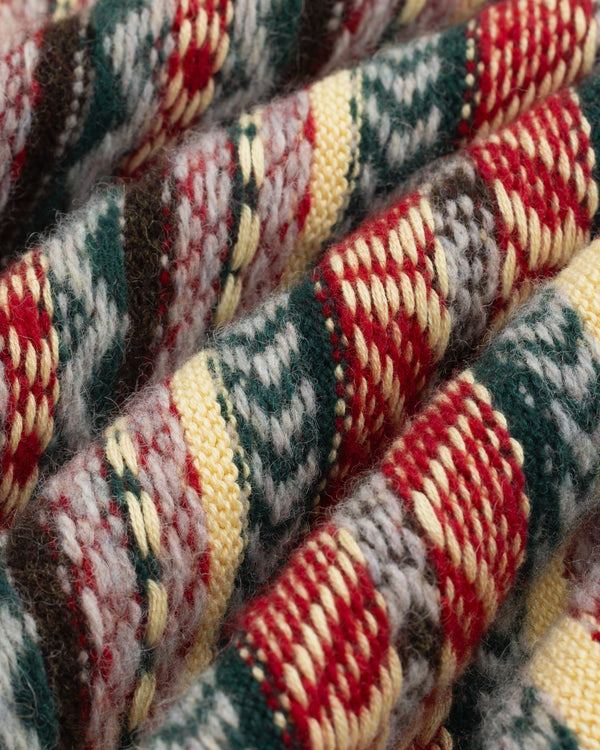 Close-up of Fair Isle V-Neck Sweater knit with red, green, yellow, and white patterns in textured rows.