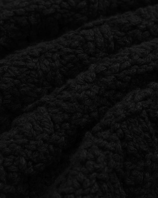 Close-up of a black Checkerboard Bouclé Sweater with a textured, looped knit pattern.