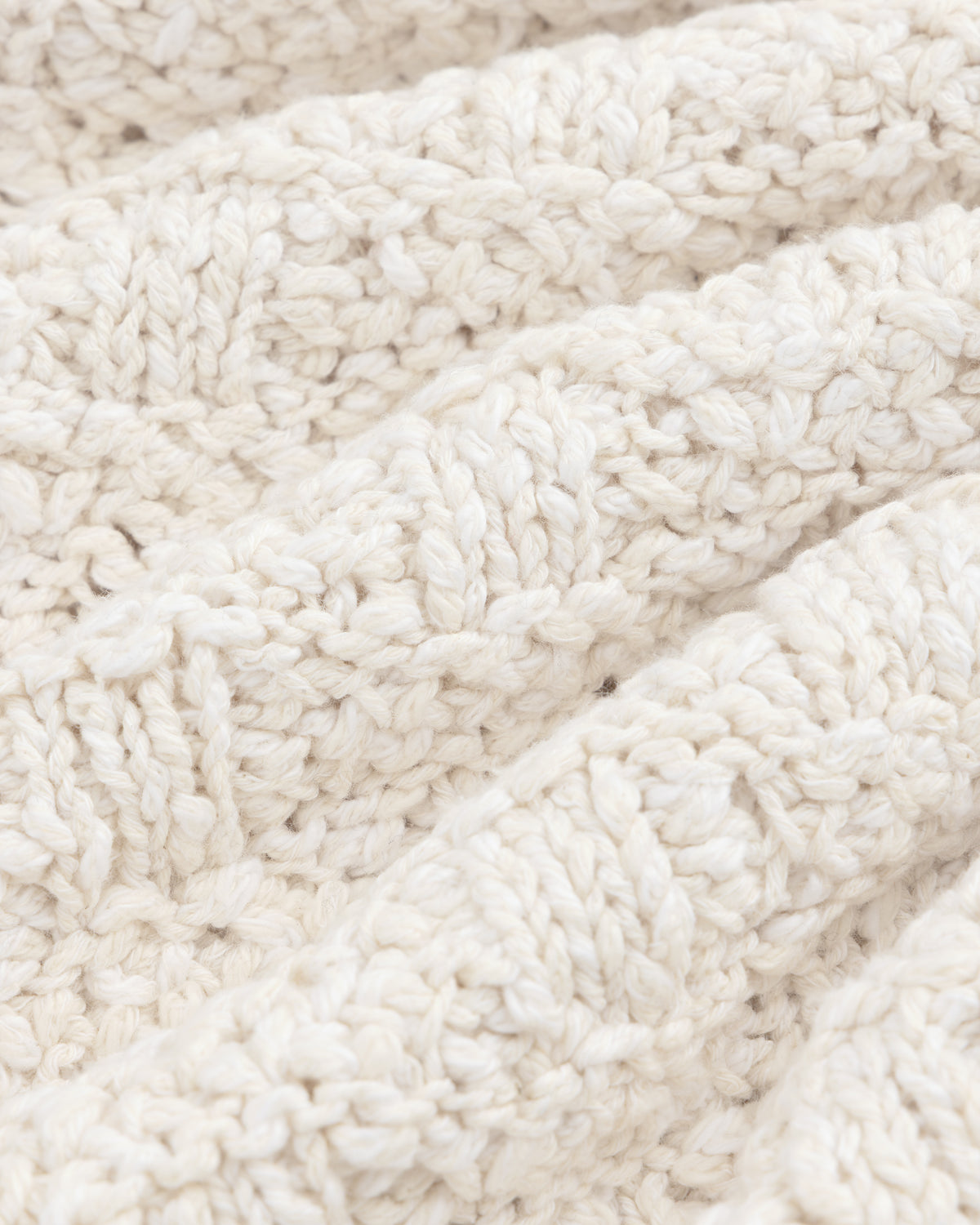 Close-up of the Checkerboard Bouclé Sweater in off-white knit fabric with a textured, looped pattern.