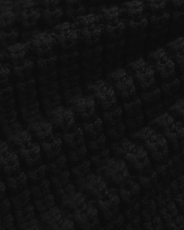 Close-up of a black chunky ribbed knit Merino Wool Full Zip Sweater.