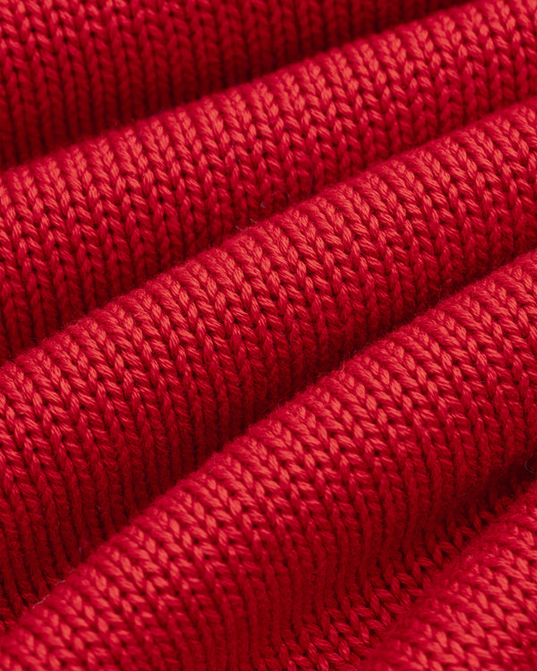 Close-up of red knit fabric with horizontal ridges on a Knit Pocket Crewneck Sweater.