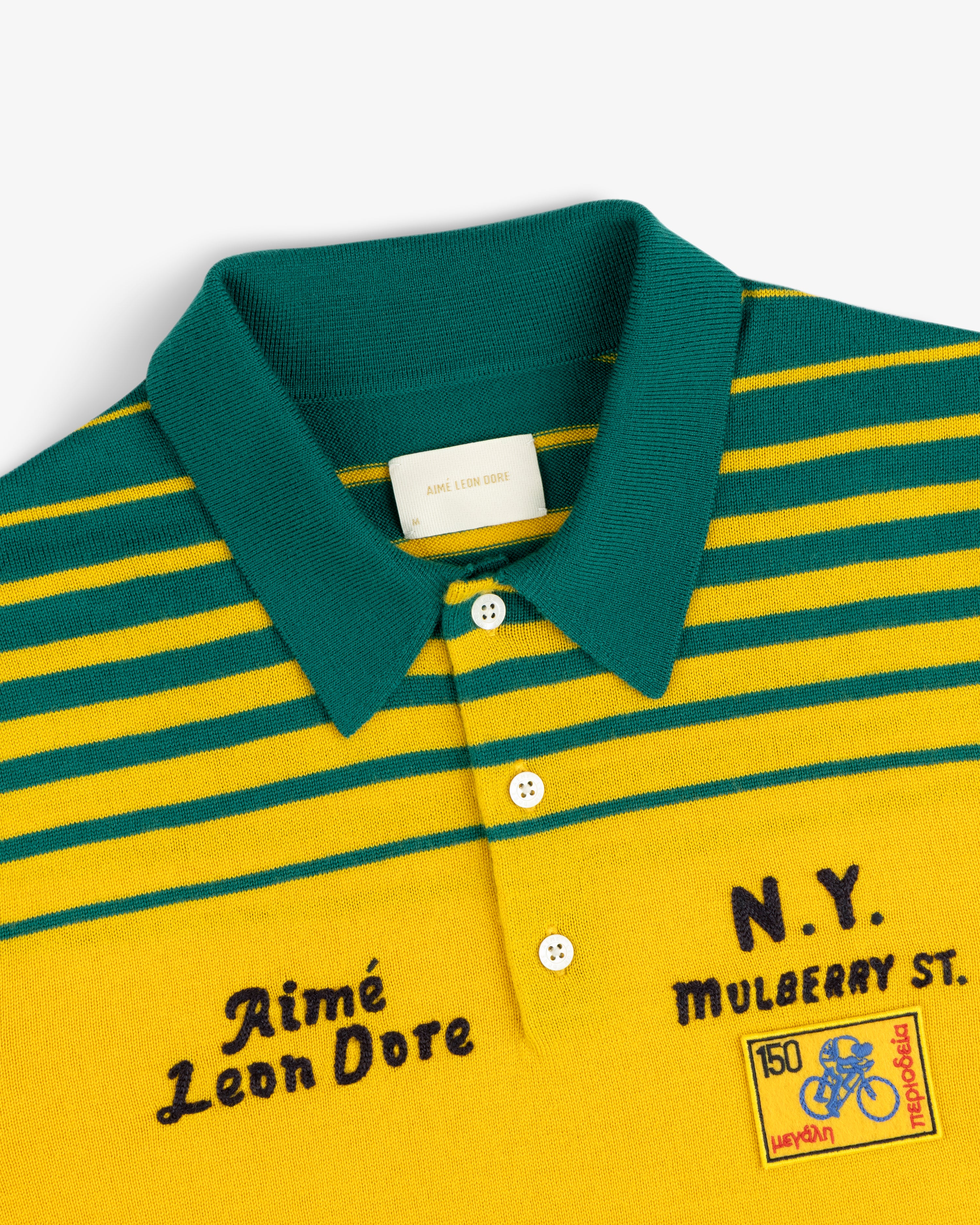 Merino Wool Knit Cycling Polo with yellow and green stripes, collar, buttons, embroidery, and chest patches.