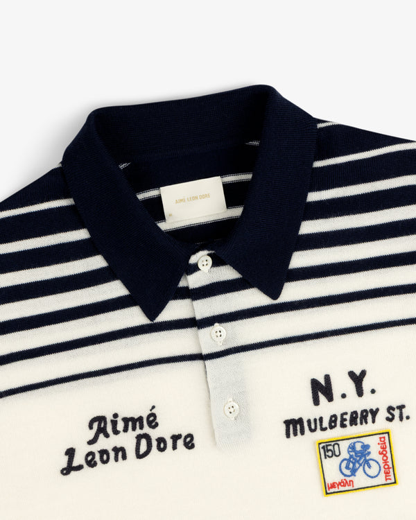 Merino Wool Knit Cycling Polo with navy and white stripes, embroidered patches, and Aimé Leon Dore text.