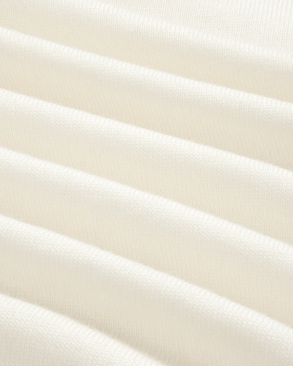 Close-up of Merino Wool Knit Cycling Polo’s soft, cream fabric with gentle folds and subtle ribbed texture.
