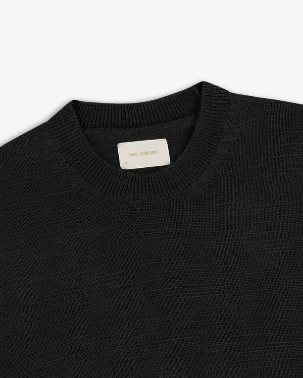 Black Slub Merino Wool sweater with a textured knit and an interior brand label at the collar.