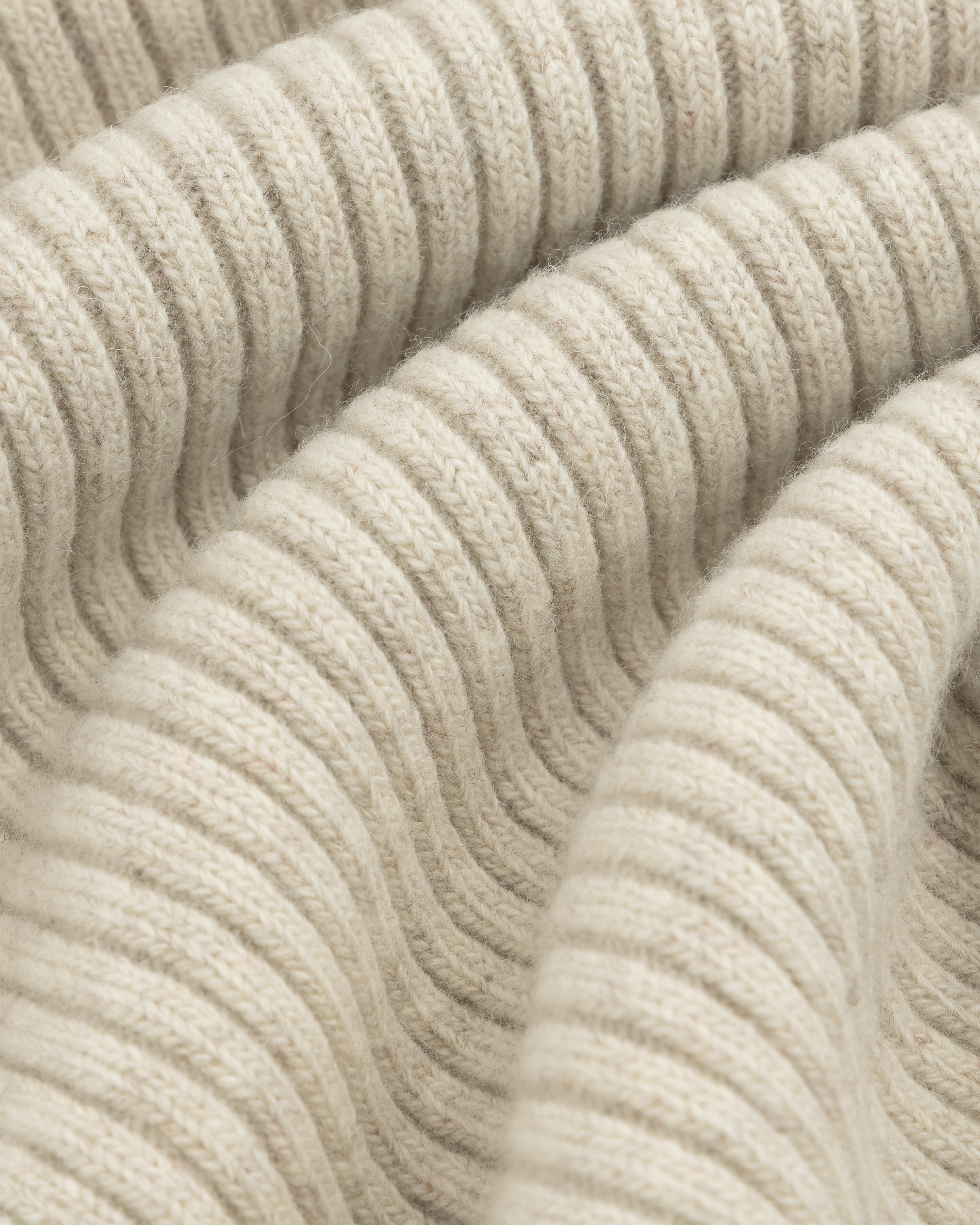 Close-up of beige Wool Ribbed Knit Hoodie fabric showing soft, ribbed folds.