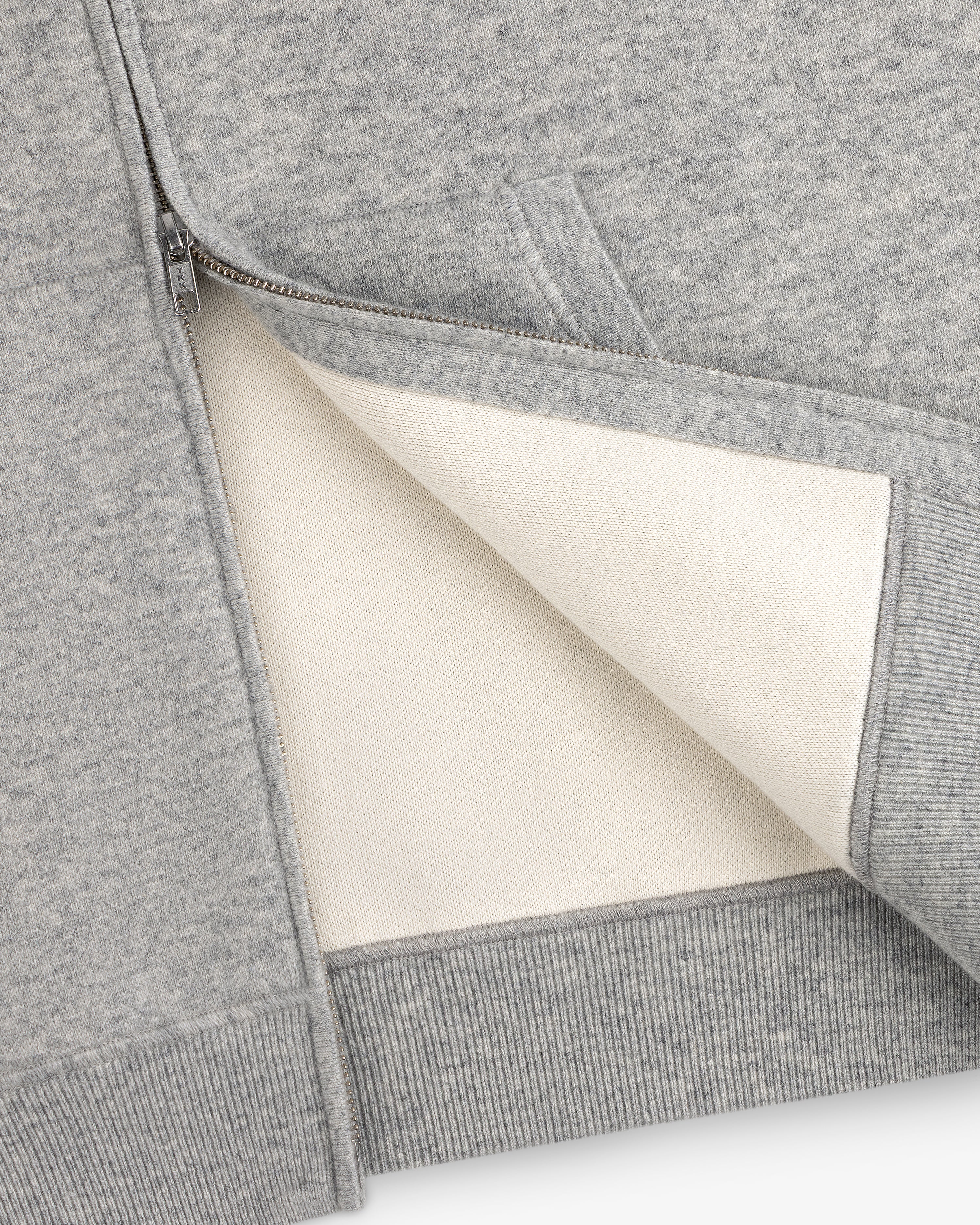 Close-up of the Full-Zip Pavilion Cashmere Hoodie, unzipped to reveal its soft off-white lining and detailed pocket.