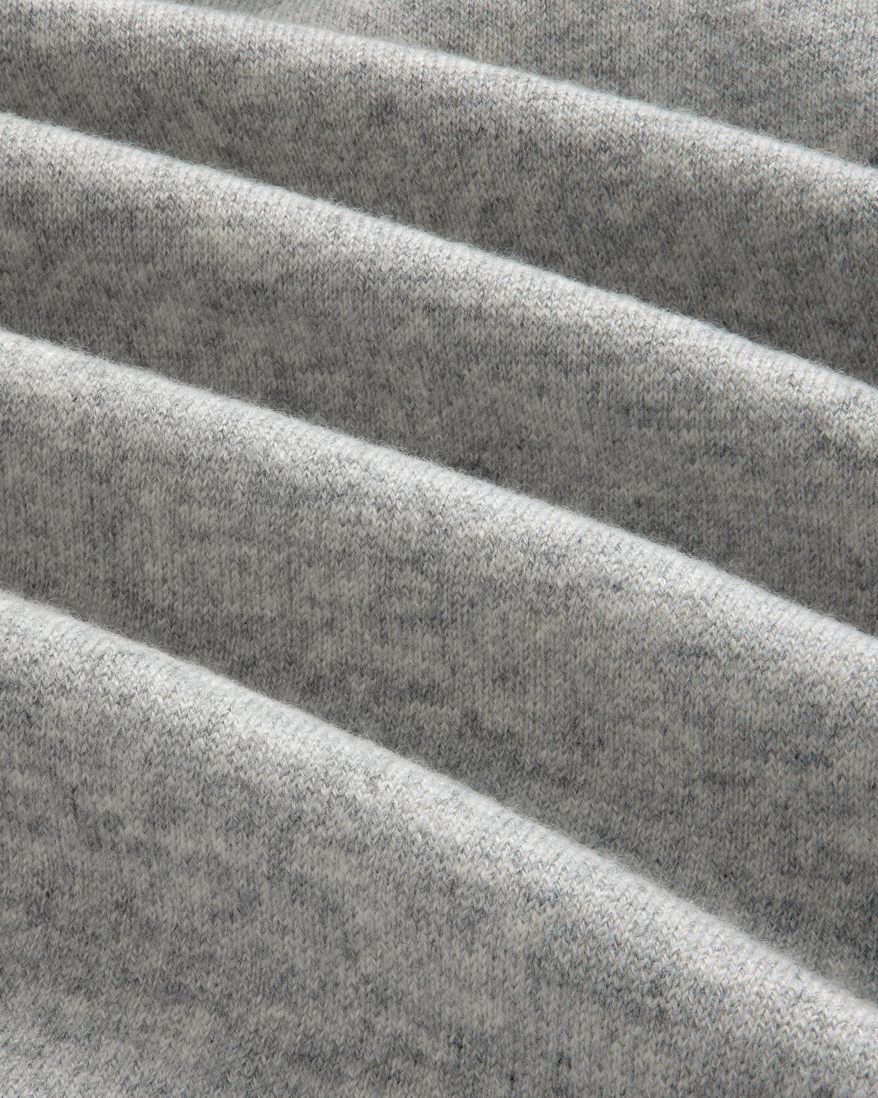 Close-up of folded, soft Pavilion Cashmere Hoodie in heather gray, showing texture and diagonal, parallel folds.