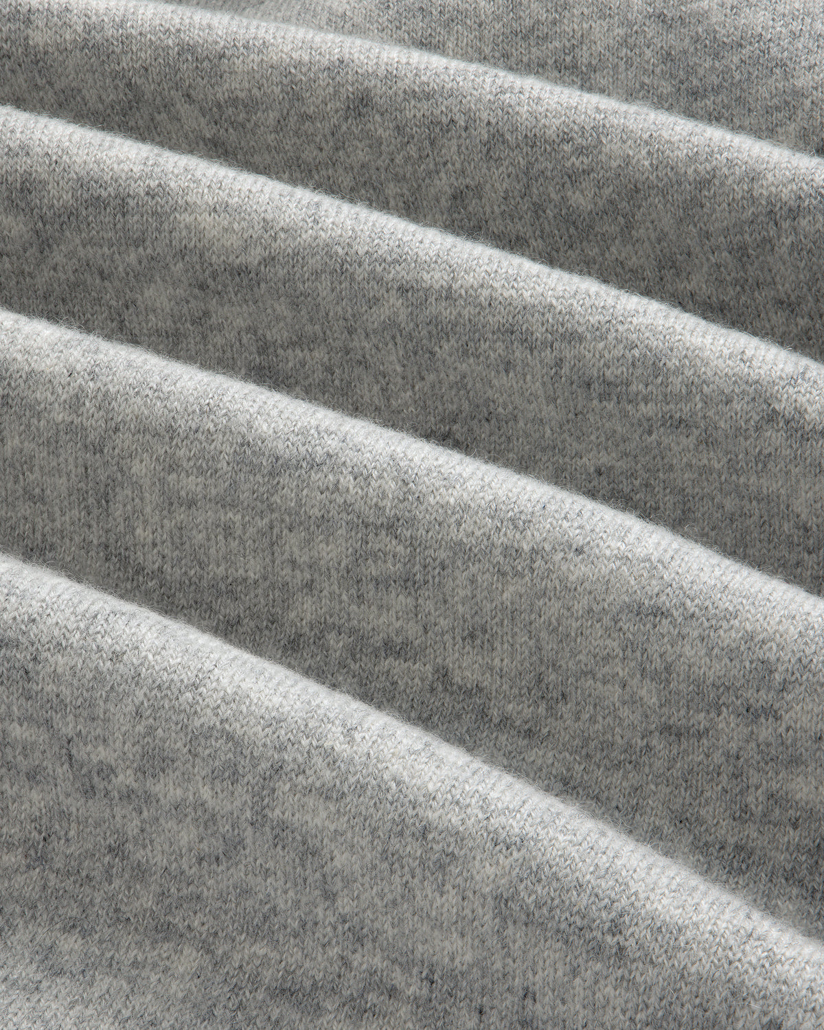 Close-up of folded Pavilion Cashmere Sweatpant in light gray, showing its soft, textured surface with horizontal ridges.
