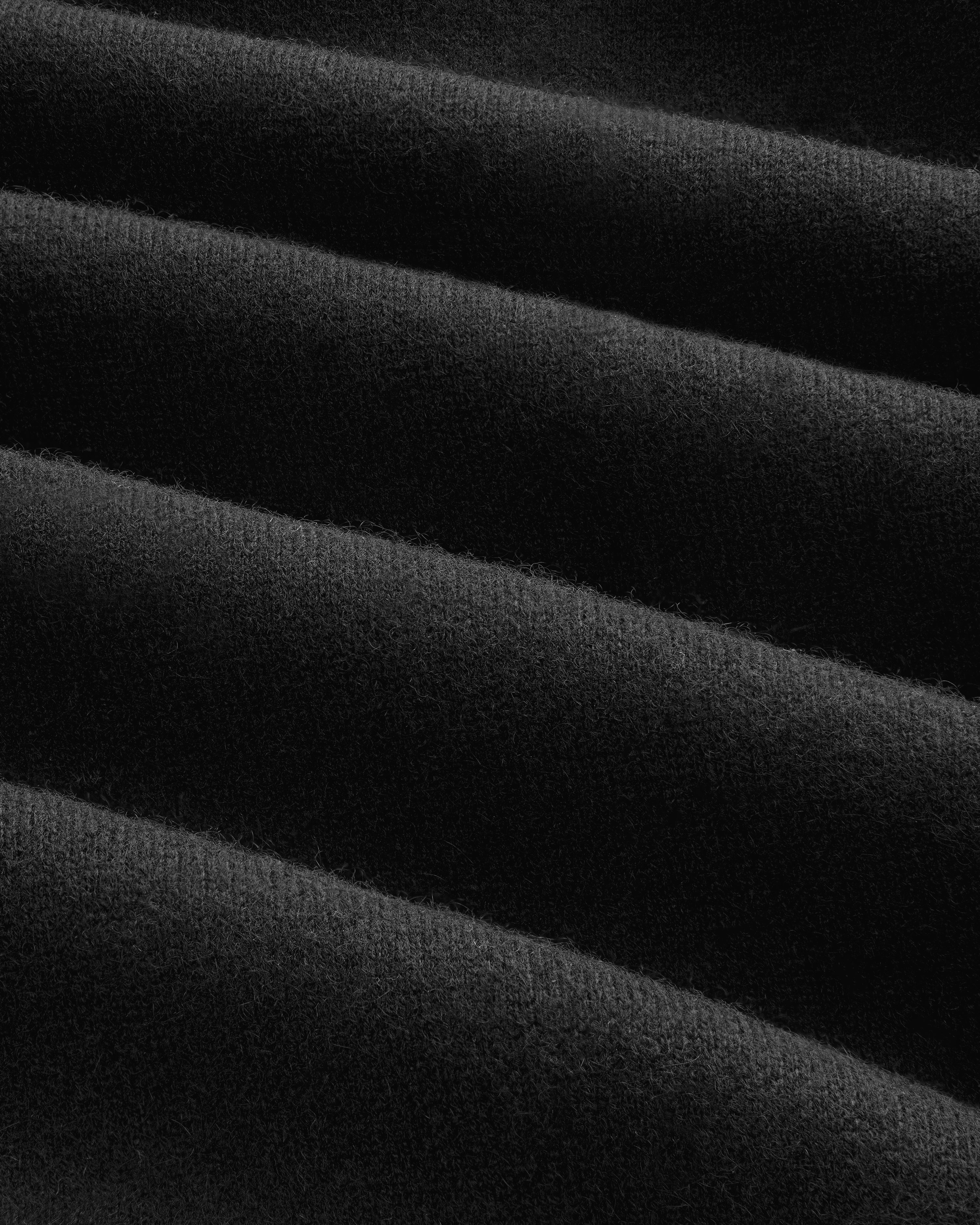 Close-up of Pavilion Cashmere Sweatpant: soft black fabric with even horizontal ridges and a velvety texture.