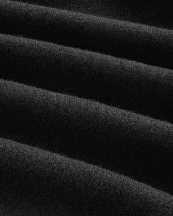 Close-up of soft, black Pavilion Cashmere Hoodie fabric with ridges and diagonal folds creating texture.