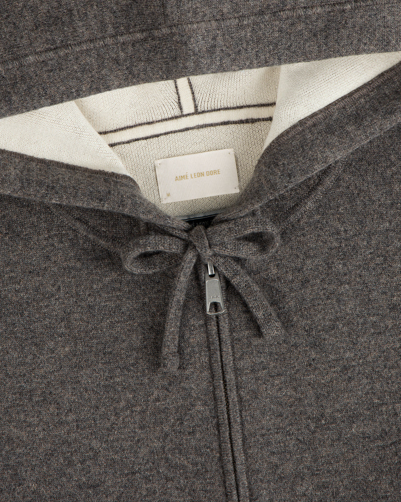 Close-up of a brown Full-Zip Pavilion Cashmere Hoodie with drawstring and visible Aimé Leon Dore label in the collar.