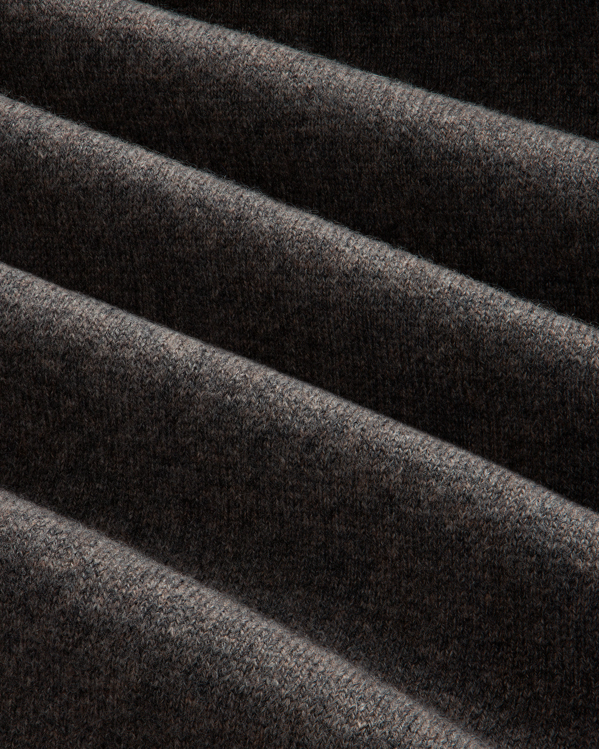 Close-up of Pavilion Cashmere Sweatpant: dark ribbed fabric, soft texture, and deep diagonal folds.