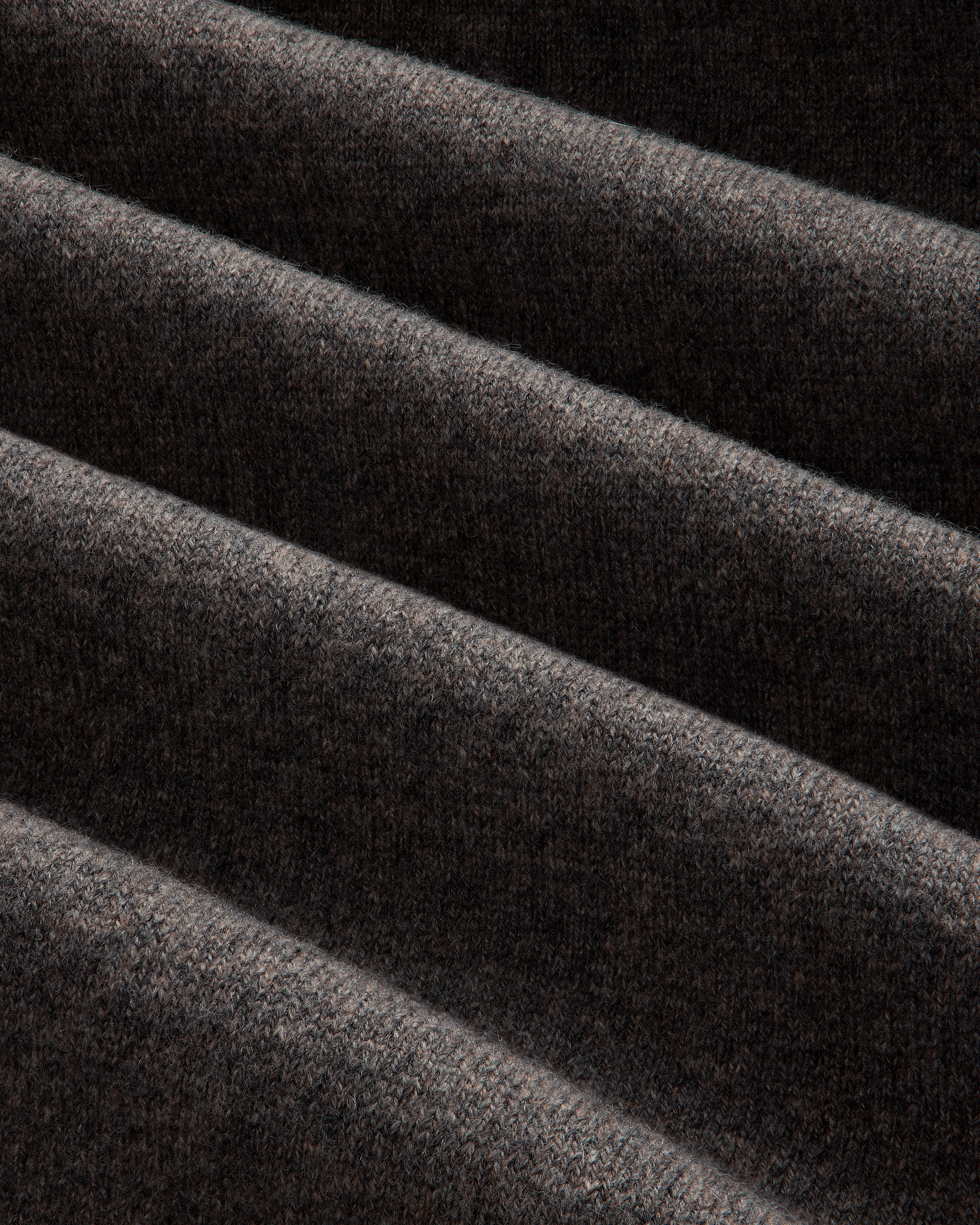 Close-up of Pavilion Cashmere Sweatpant: dark ribbed fabric, soft texture, and deep diagonal folds.
