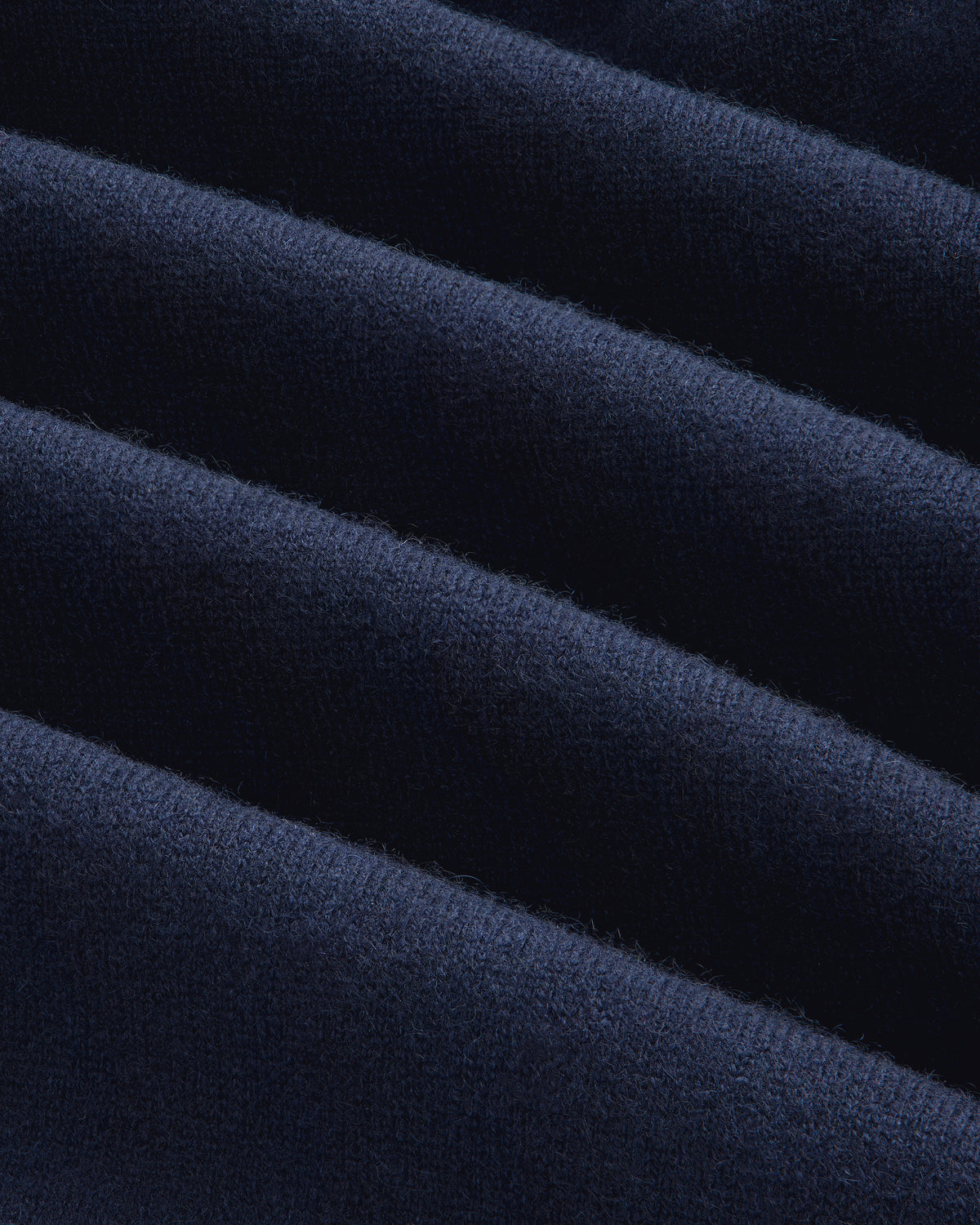 Close-up of Pavilion Cashmere Sweatpant in dark blue velvet with soft texture and gentle diagonal folds.