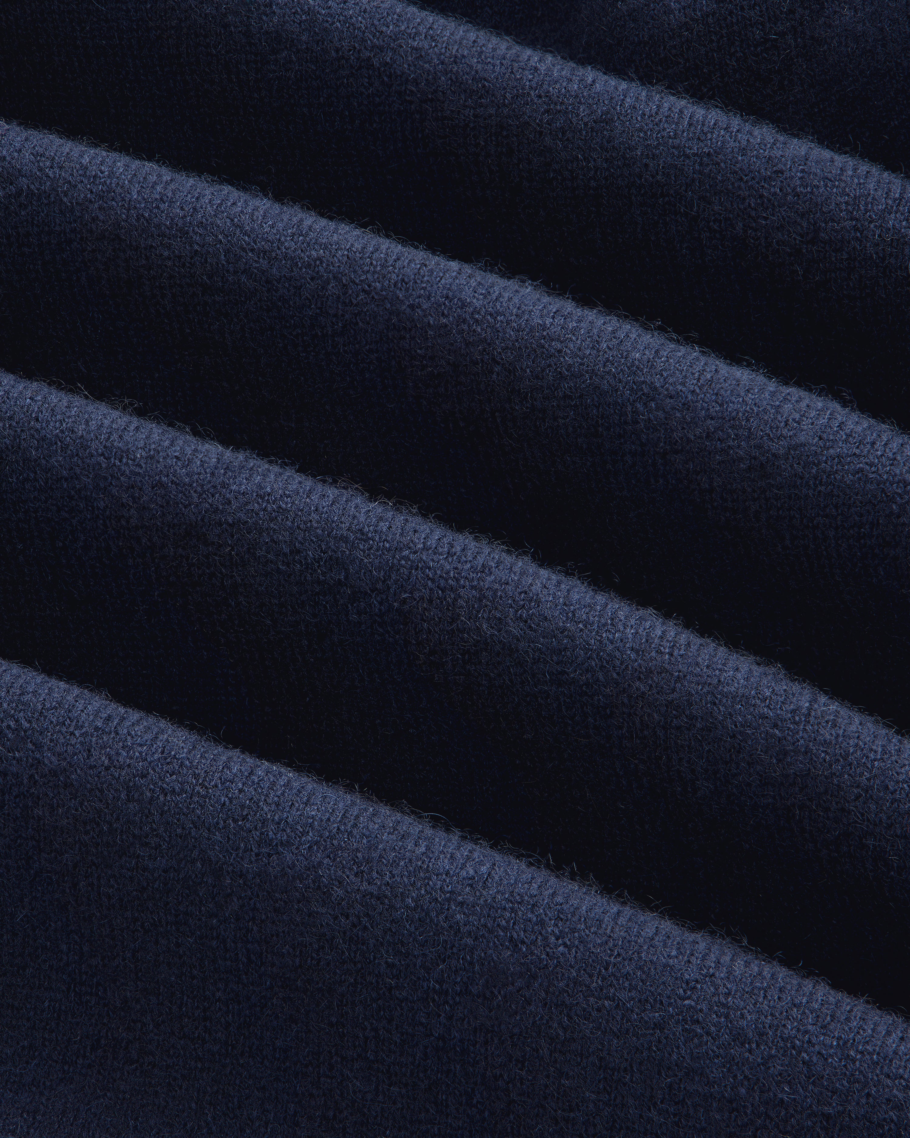 Close-up of Pavilion Cashmere Sweatpant in dark blue velvet with soft texture and gentle diagonal folds.