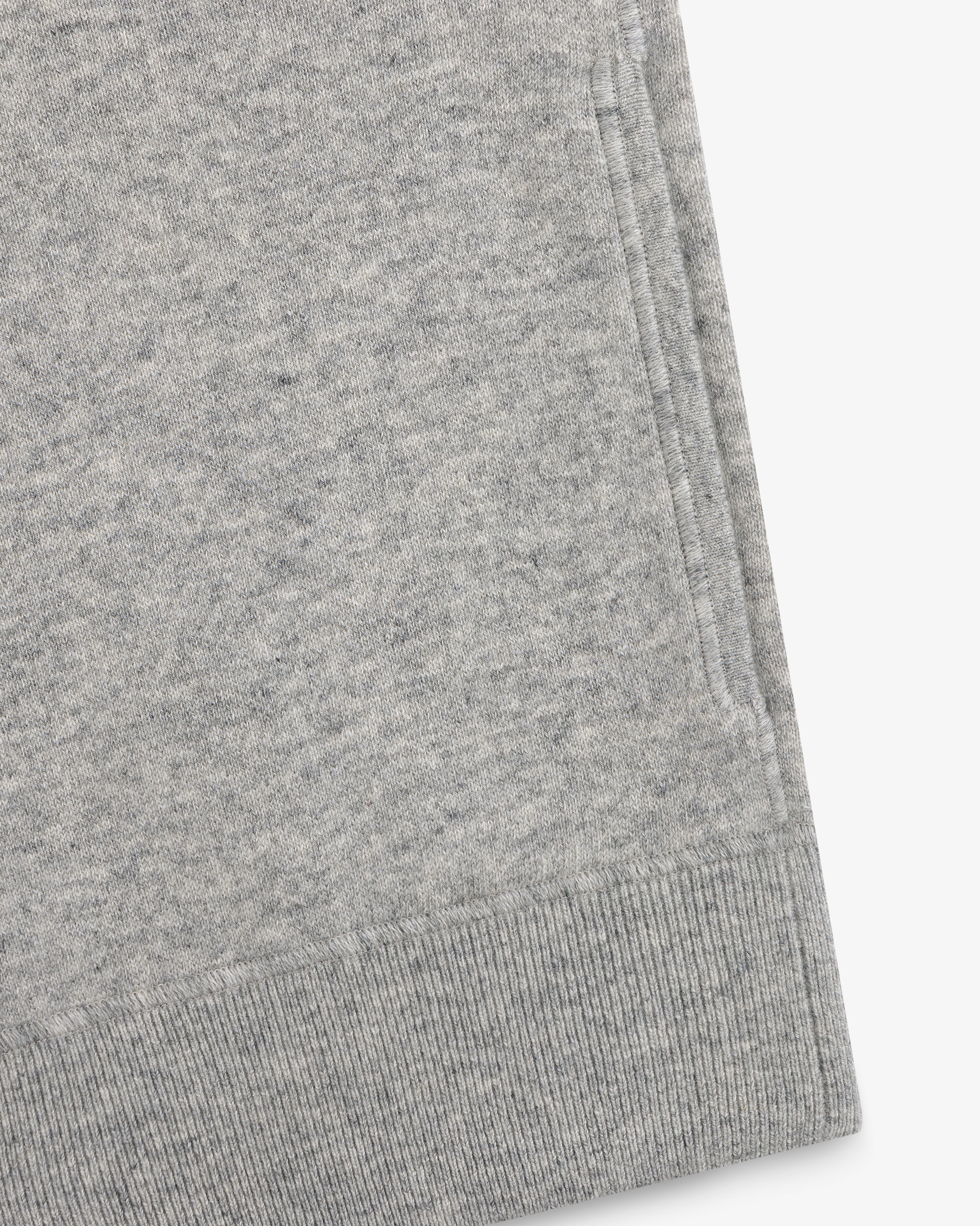 Close-up of a gray Quarter Zip Pavilion Cashmere Pullover, highlighting its pocket and ribbed hem details.