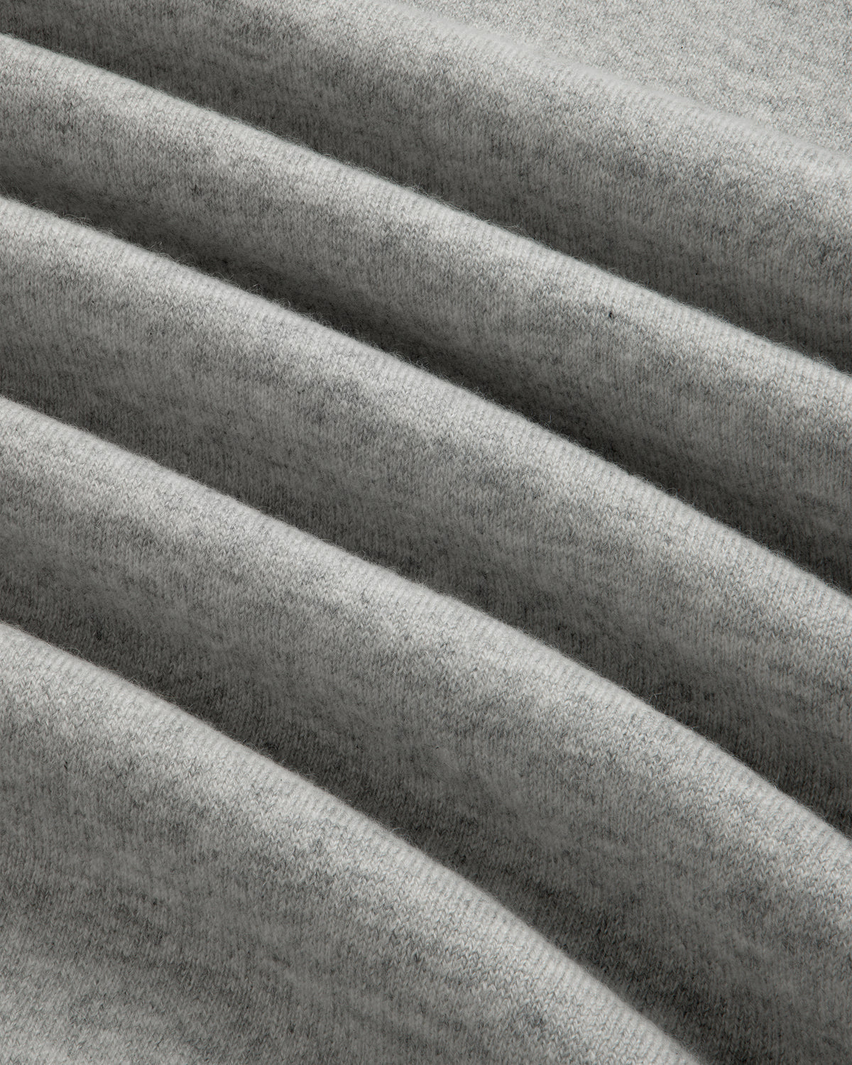 Close-up of the Quarter Zip Pavilion Cashmere Pullover in soft, light gray with gentle, evenly spaced folds.