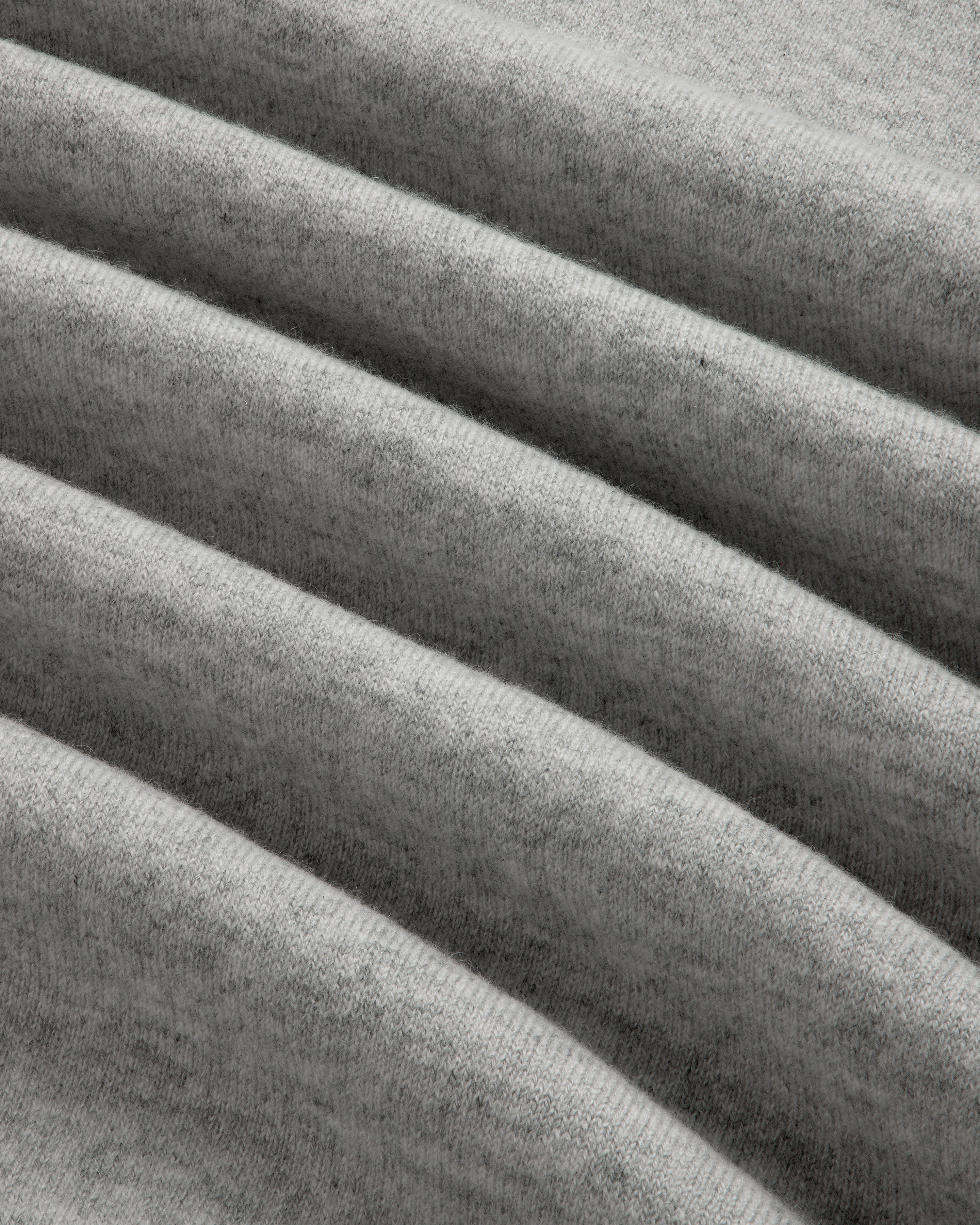 Close-up of the Quarter Zip Pavilion Cashmere Pullover in soft, light gray with gentle, evenly spaced folds.