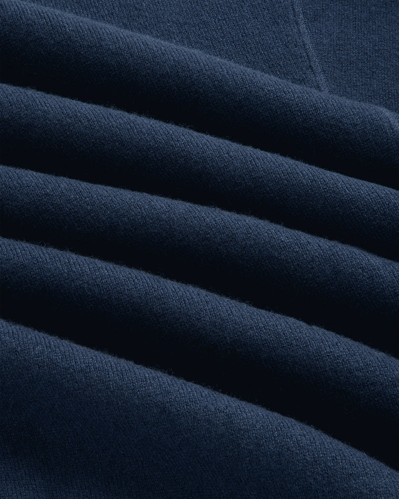 Close-up of folded navy Pavilion Cashmere Pullover with textured fabric and soft, even lighting.