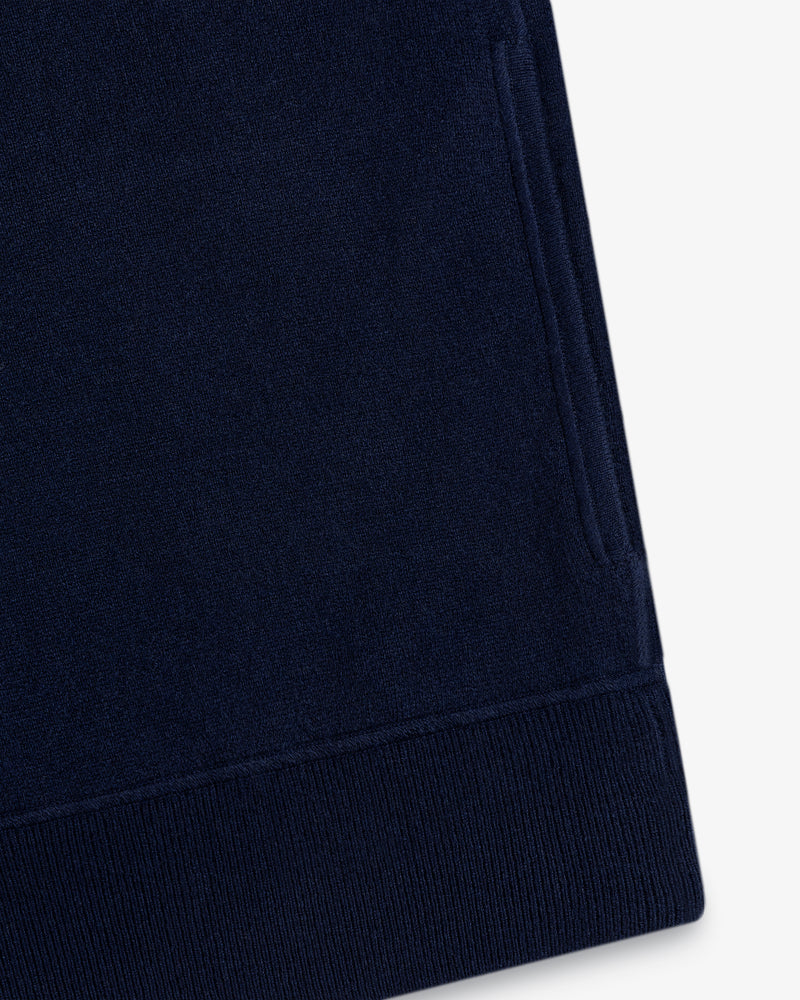 Close-up of a Quarter Zip Pavilion Cashmere Pullover in navy blue with pocket and ribbed hem on white background.