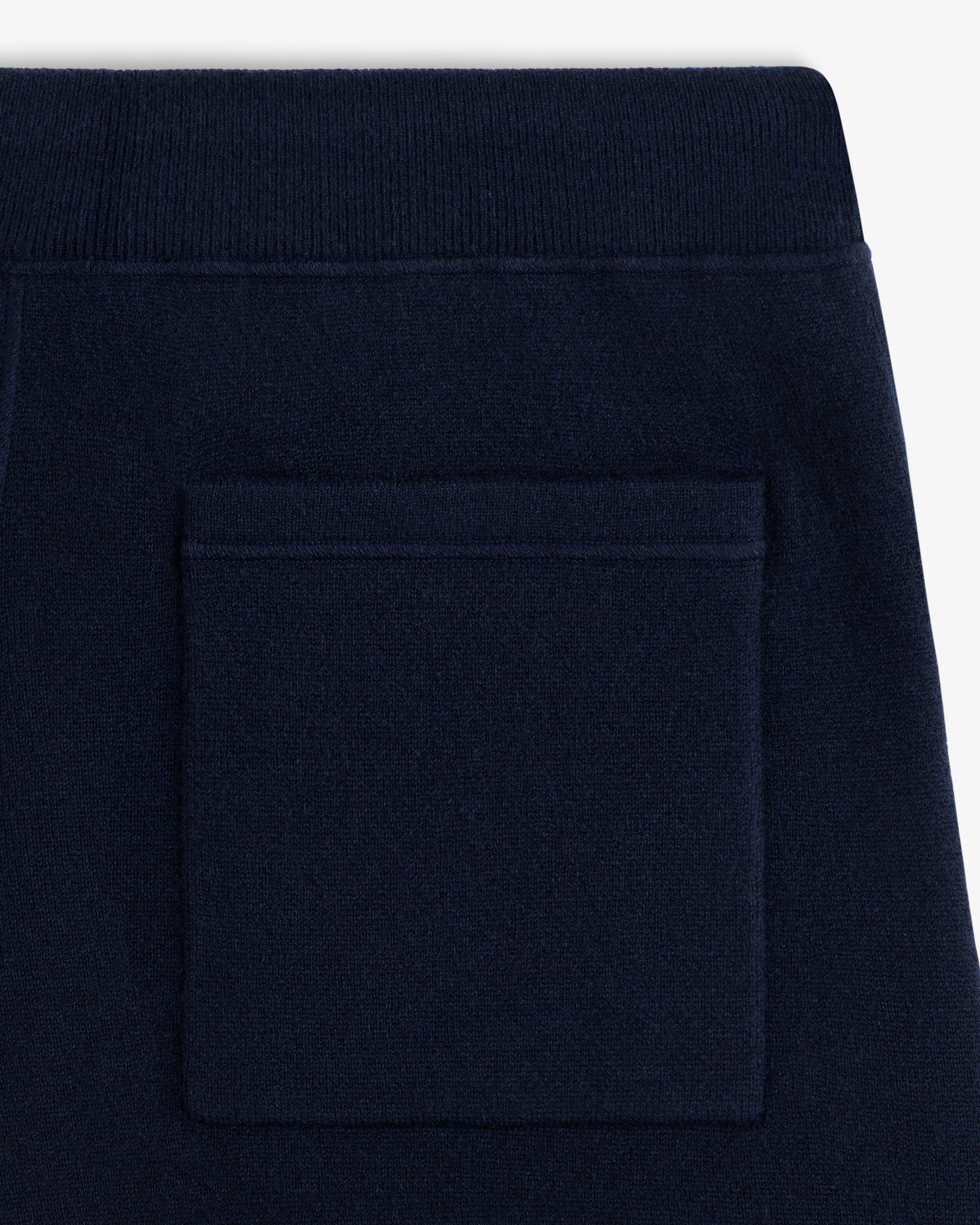 Close-up of Pavilion Cashmere Sweatpant in navy with a square back pocket and ribbed waistband.