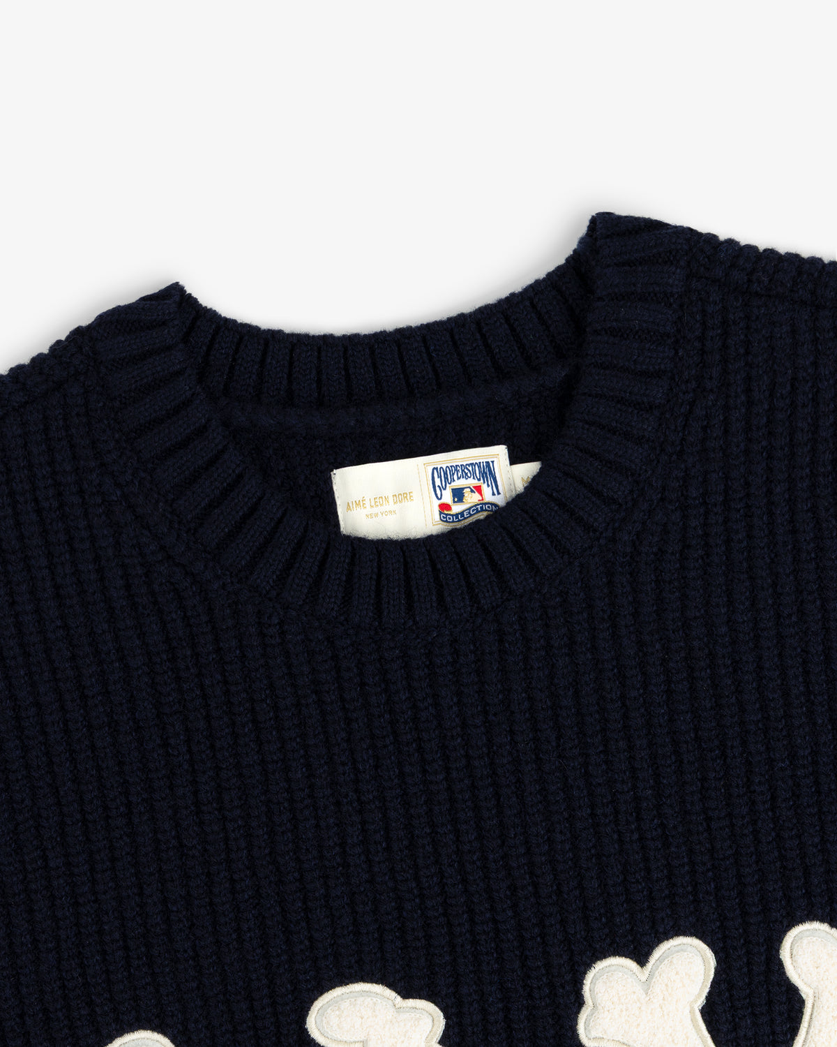 Close-up of the NY Highlanders Ribbed Wool Crewneck Sweater with a white patch detail and branded collar tag.