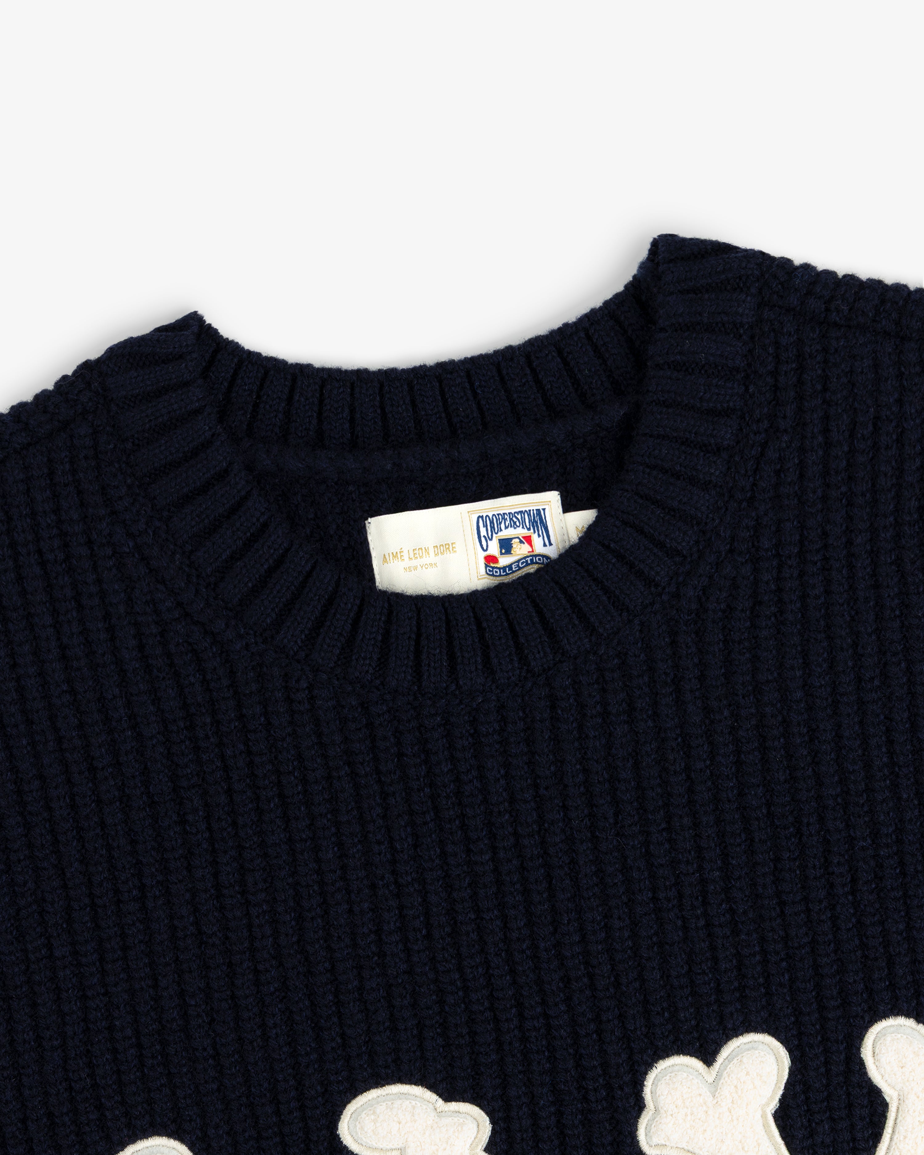 Close-up of the NY Highlanders Ribbed Wool Crewneck Sweater with a white patch detail and branded collar tag.