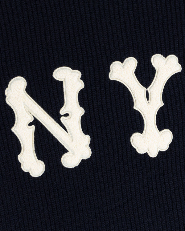 White ‘N’ and ‘Y’ letters featured on the NY Highlanders Ribbed Wool Crewneck Sweater’s dark, ribbed background.