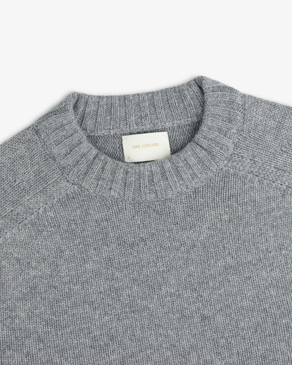 Gray Cashmere Crewneck Sweater with a ribbed neckline and a label at the collar.