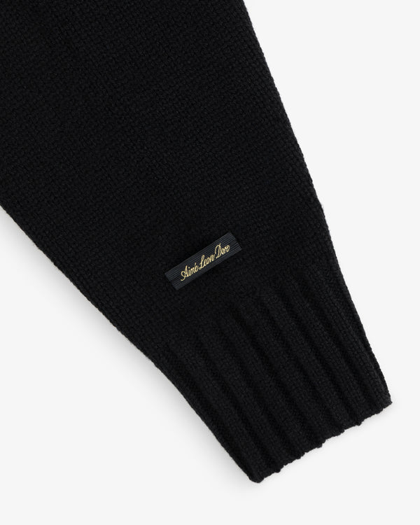 Black Cashmere Crewneck Sweater sleeve with a ribbed cuff and a small branded label.